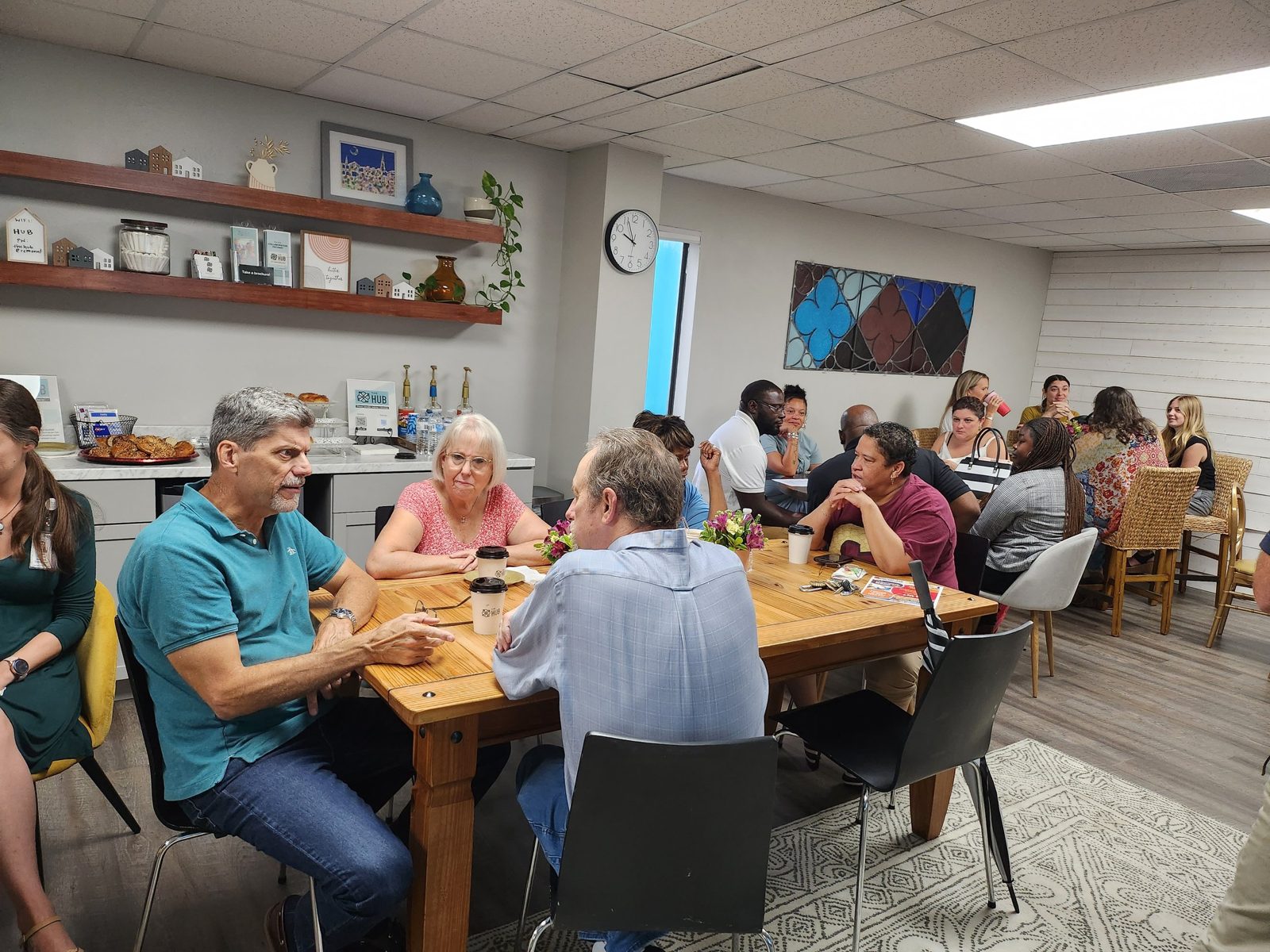 Neighbors talking around tables in the Hub's lounge