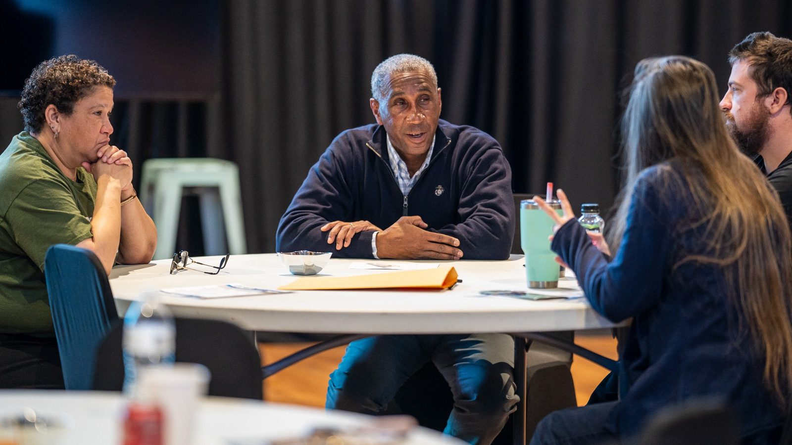 A doctor in conversation at a table on campus